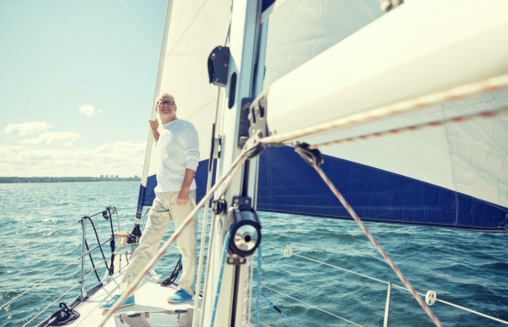 senior man on sail boat or yacht sailing in sea